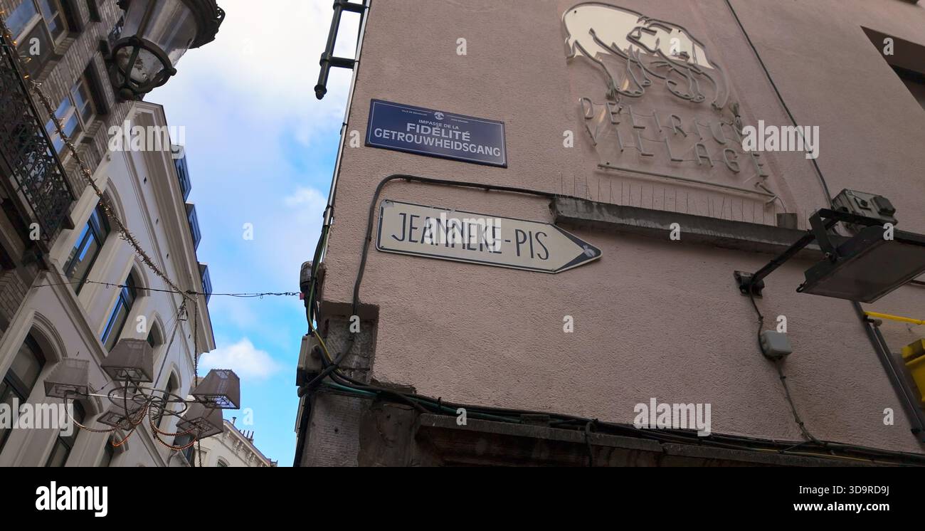 BRUSSELS, BELGIUM - NOVEMBER 26, 2025 - Street signs pointing towards Jeanneke Pis and Delirium Village on a building corner Stock Photo
