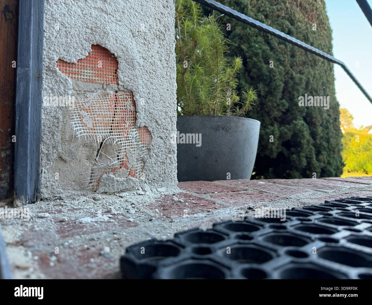 The outer layer of insulation of a house thermal insulation composite system is damaged and the components are crumbled on the floor, in the backgroun Stock Photo