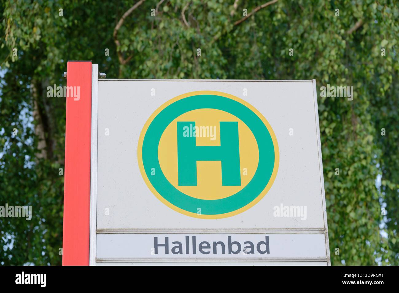 The photo shows a modern German bus stop with Hallenbad written on its ...