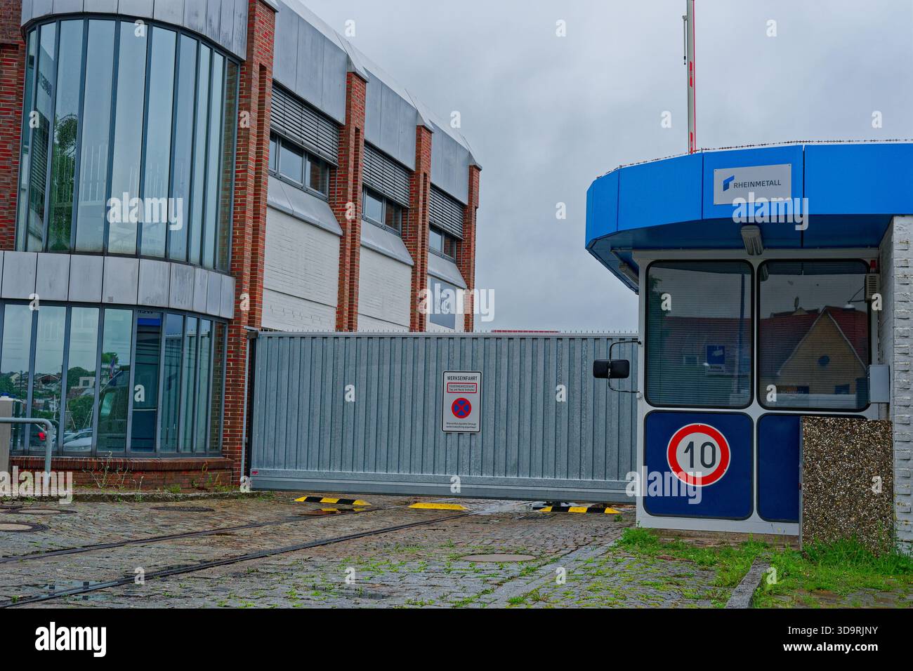 The photo shows the main entrance to the Rheinmetall factory, with a ...