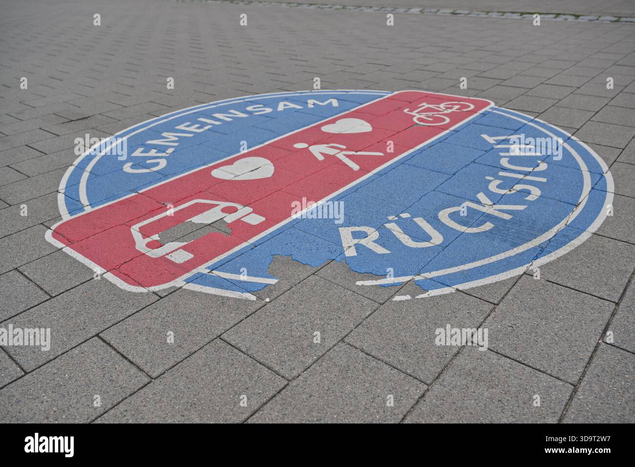 Pavement mural with symbols for cars, pedestrians, and bicycles. This promotes shared space and mutual respect among road users with words Gemeinsam t Stock Photo