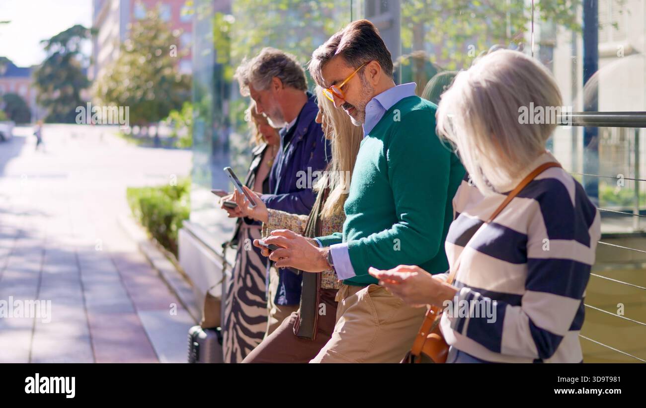 Seniors using their mobile phones outdoors Stock Photo
