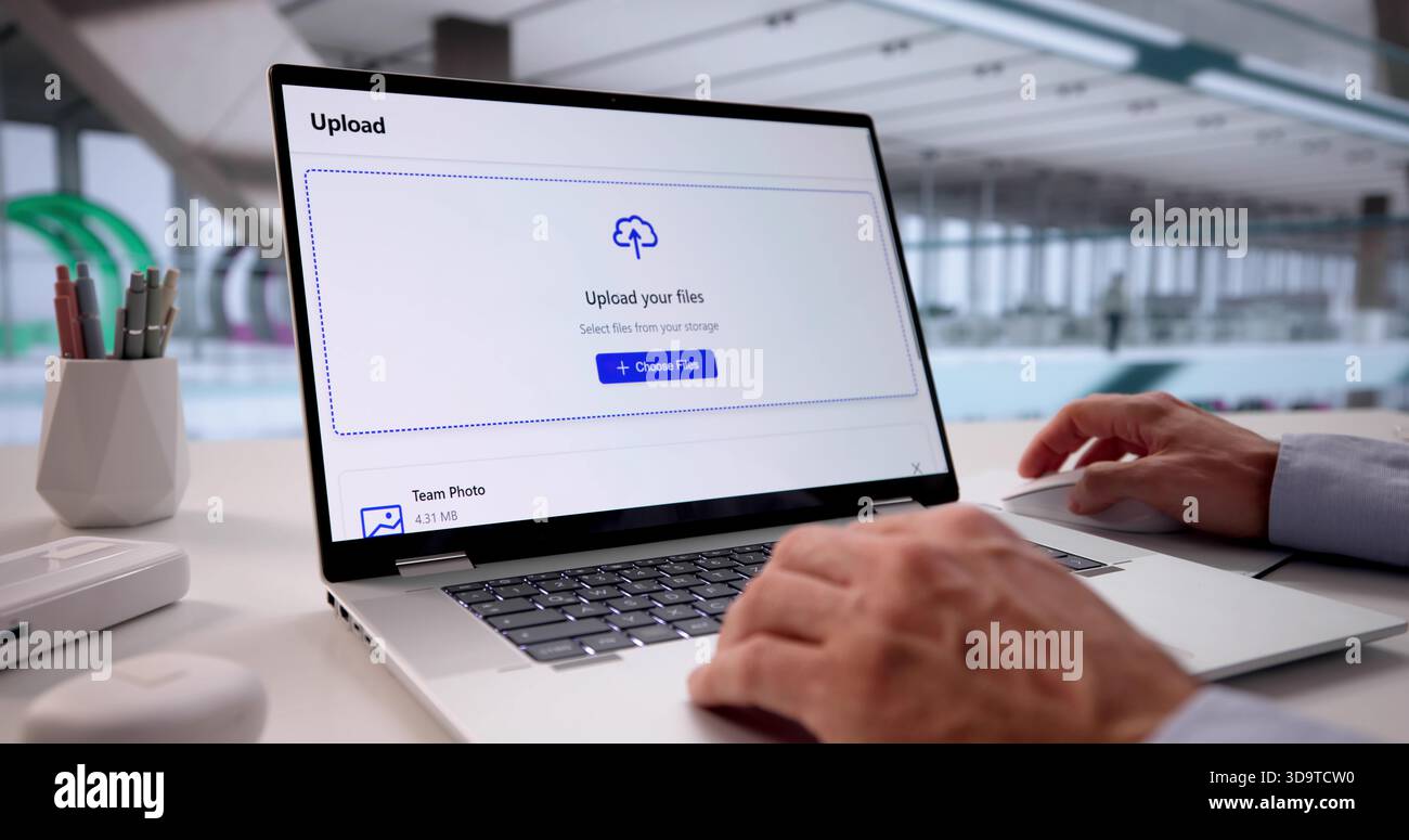 Tech-savvy Office Worker Uploading Data To Cloud Storage On Laptop. Stock Photo