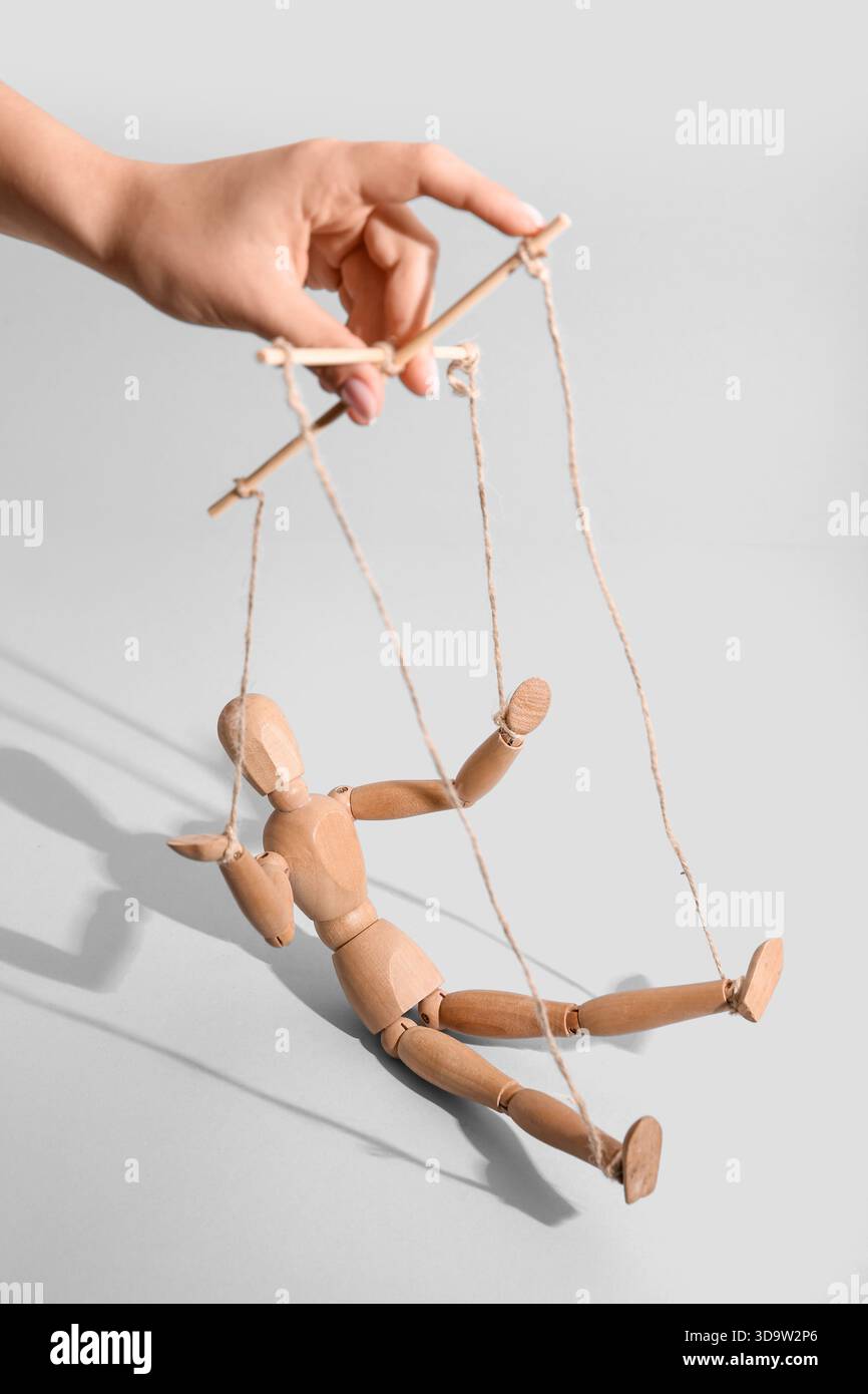 Hand of puppeteer manipulating marionette on light background Stock ...