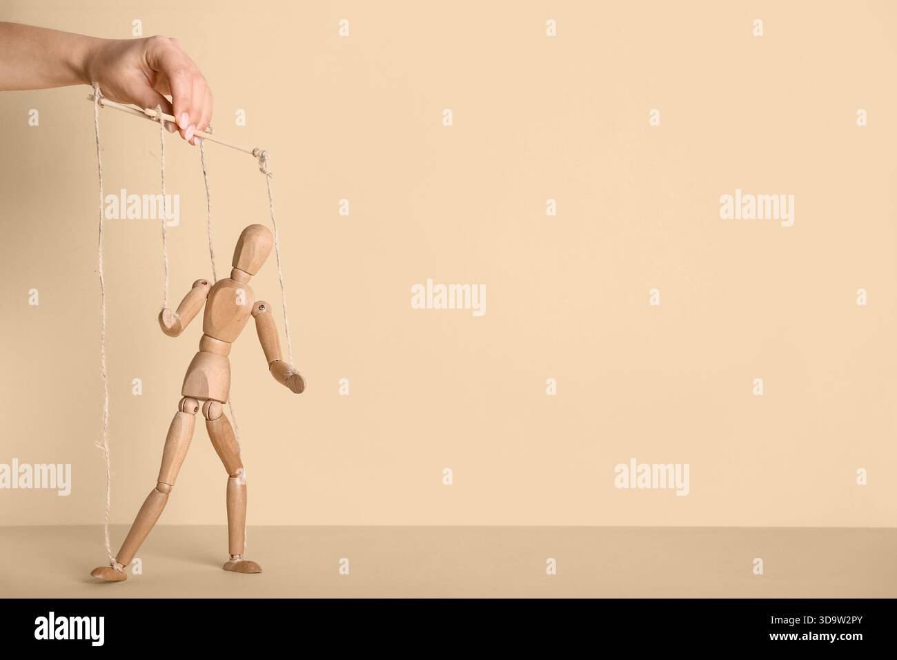 Hand of puppeteer manipulating marionette on beige background Stock ...
