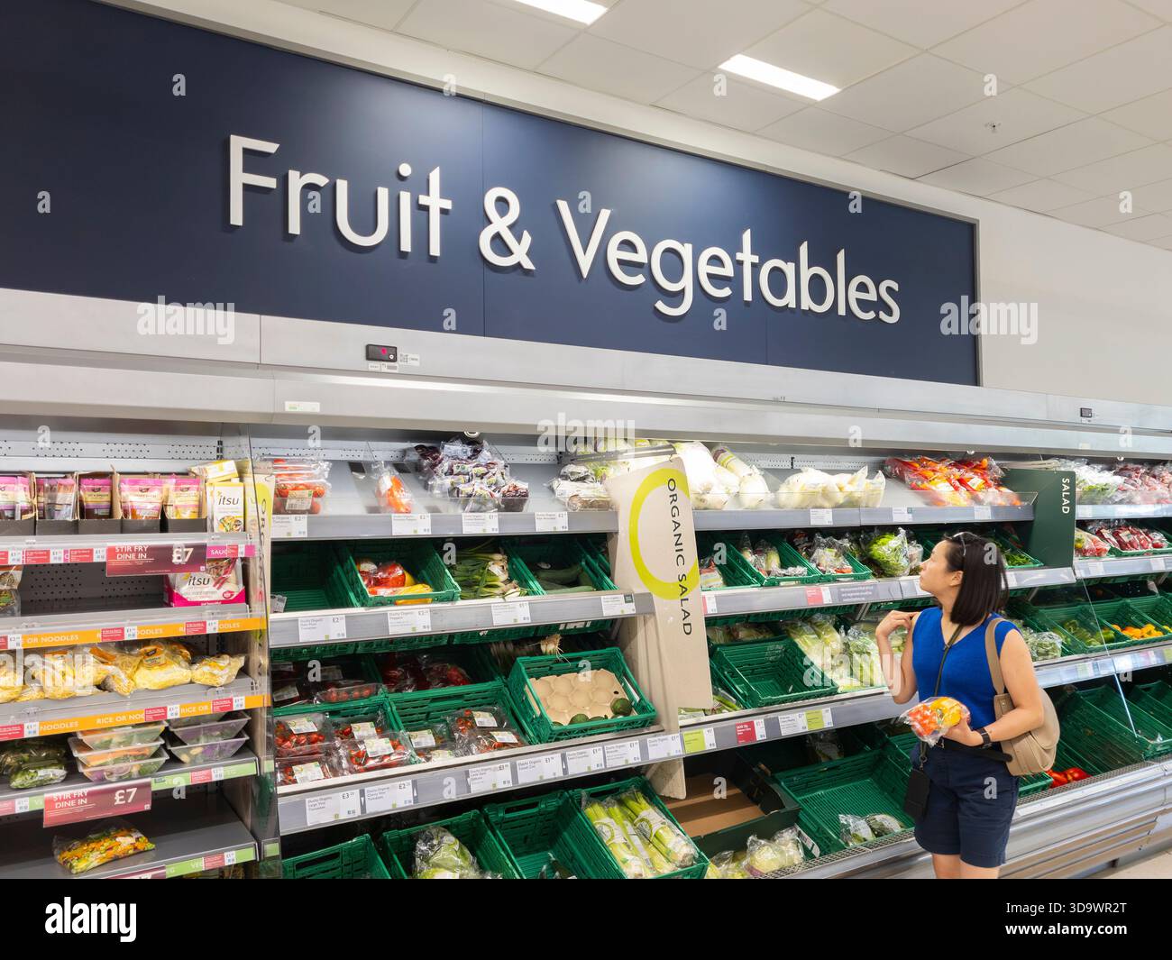 Woman shopping for fresh fruit and vegetables for sale at Waitrose supermarket, Basingstoke. Concept: cost of living, healthy food, forever chemicals - Smartphone Captured Stock Image