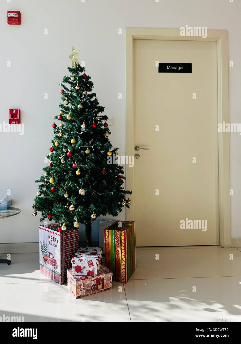 Christmas tree in office with manager sign on door - Smartphone Captured Stock Image