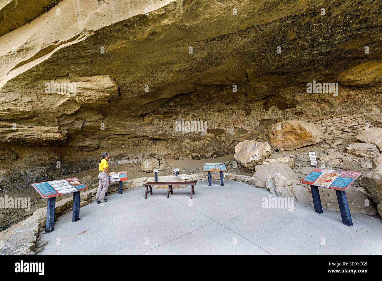Person reading information signs in the main cave in Pictograph Cave ...