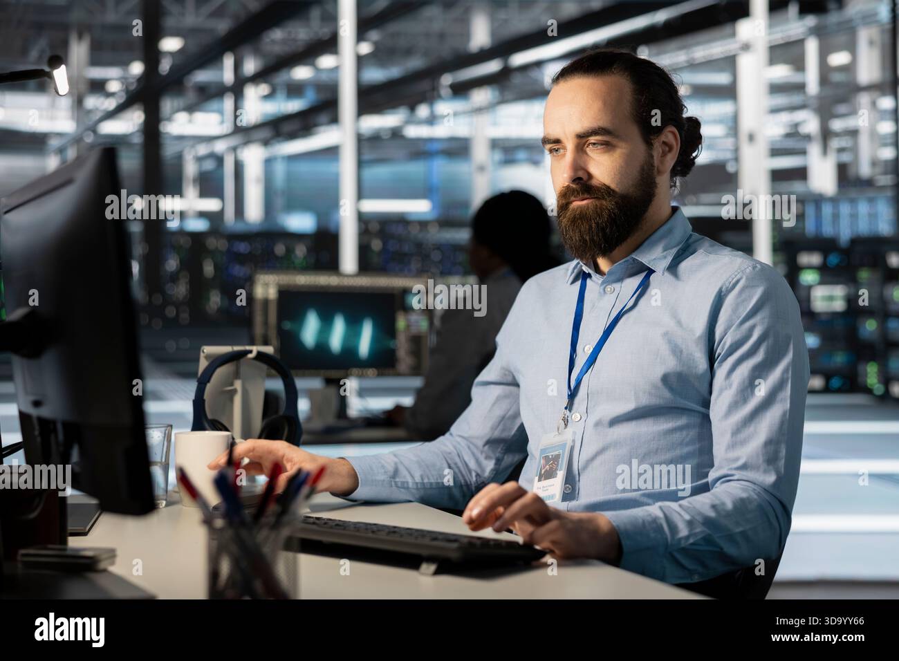 Developer in data center office doing software updates, verifying neural network parameters. Server farm employee using PC to inspect configurations, ensuring optimal application performance Stock Photo