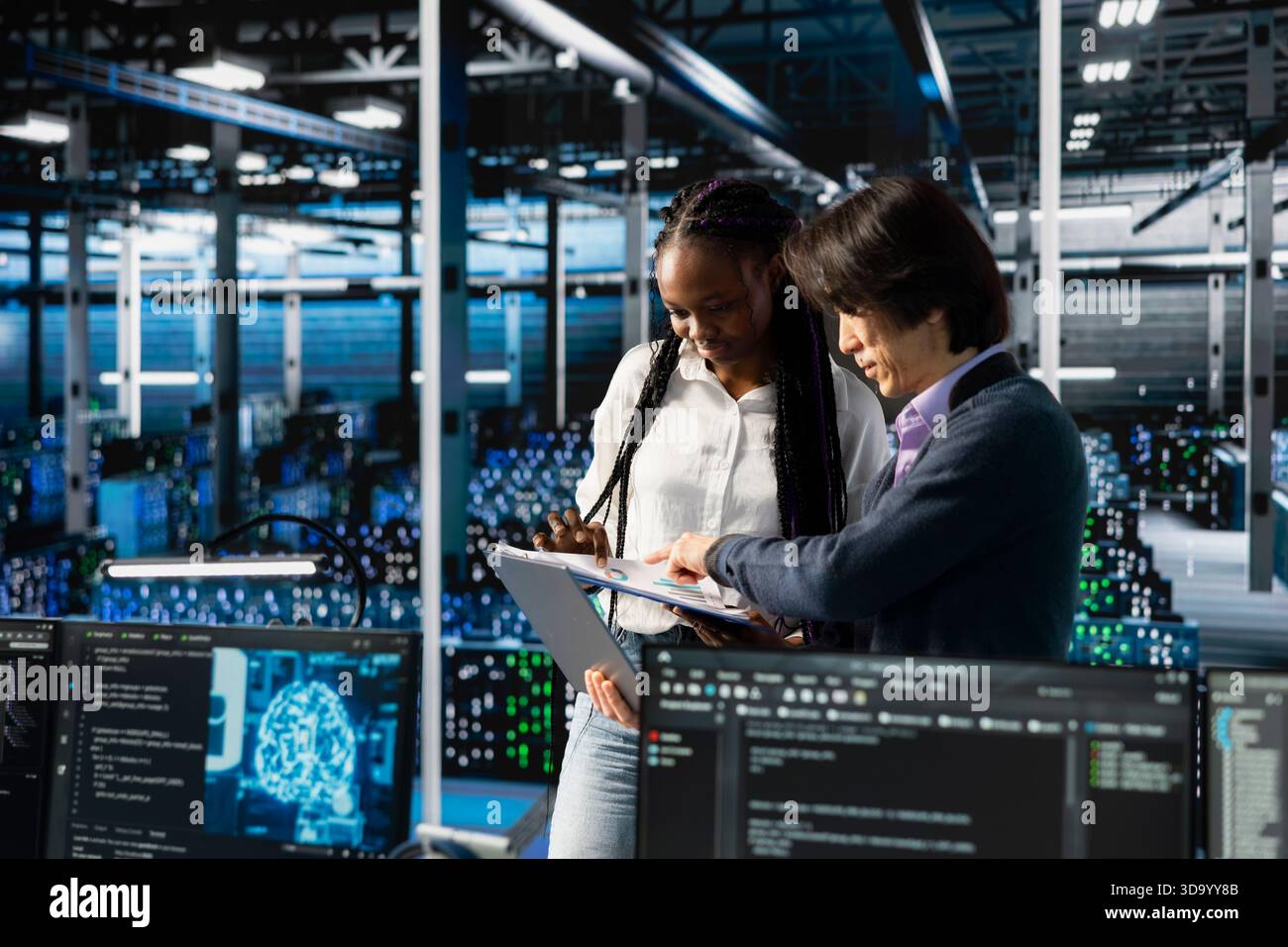 Team leader in data center teaching intern to optimize hardware for AI tasks. Server hub IT manager guiding trainee learning to automate systems using deep learning during internship Stock Photo