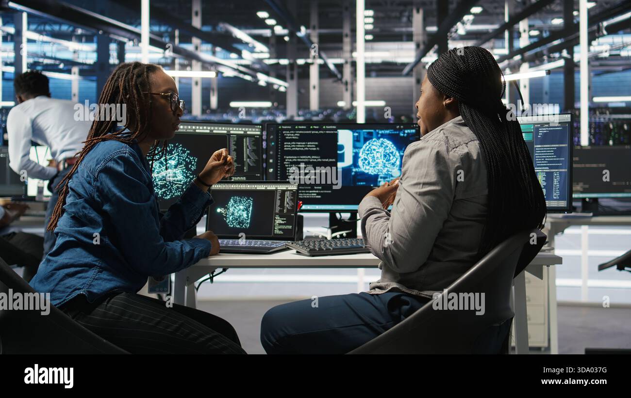Data center engineering team deploying AI solutions optimizing gear. Server hub teamworking colleagues working together, using artificial intelligence to minimize systems downtime, camera A Stock Photo