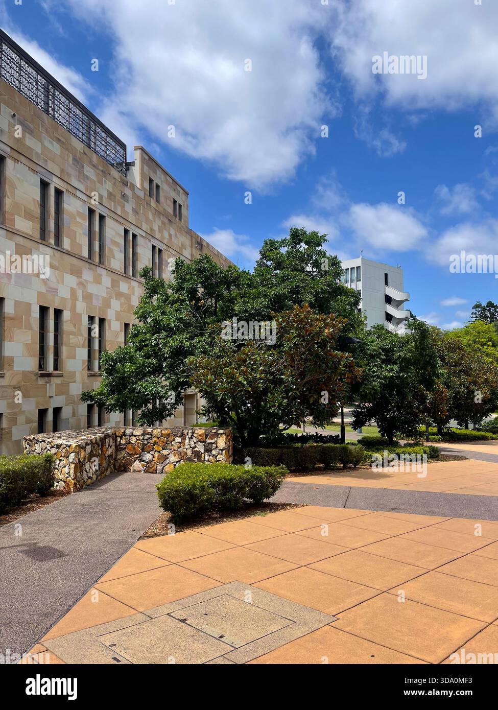 Exterior view of the University of Queensland St Lucia campus showing sandstone facade and walking paths - Smartphone Captured Stock Image