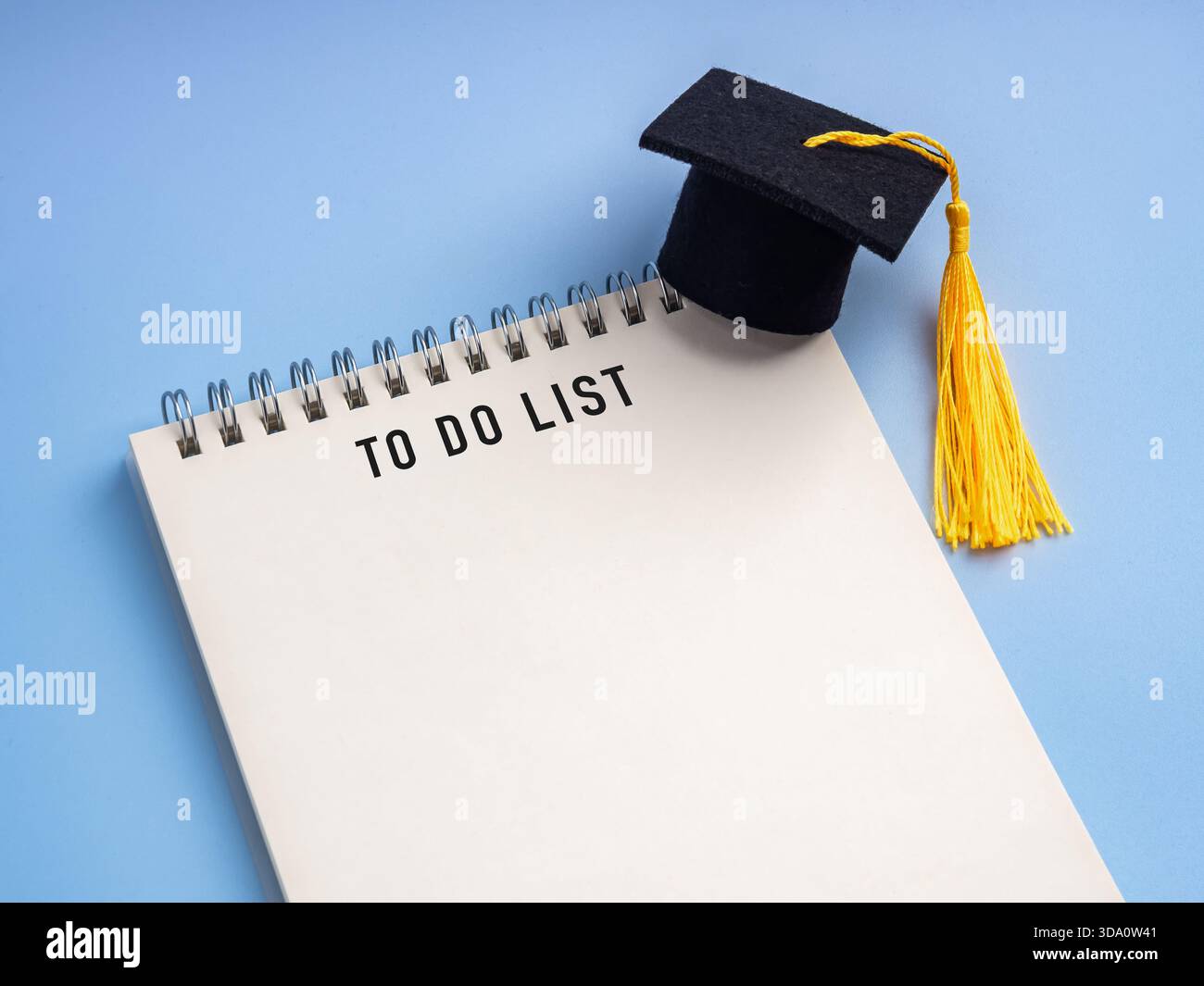 Blank space on To-do list notebook with graduation cap on blue background. Educational planning, student checklist, study goals, academic tasks, class Stock Photo