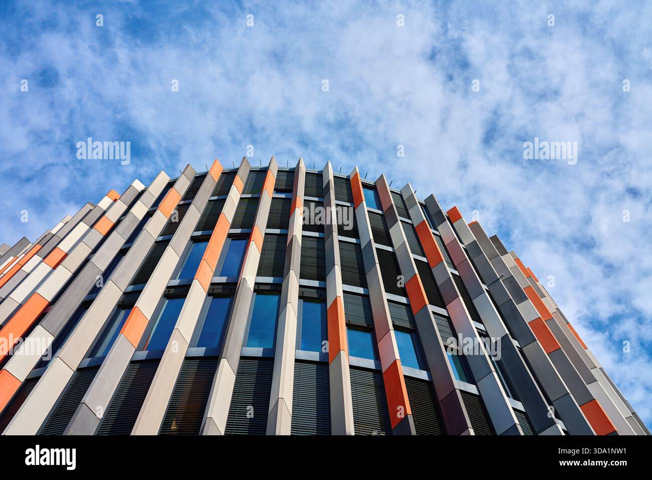 Modern office building with curved geometric facade and vertical panels ...