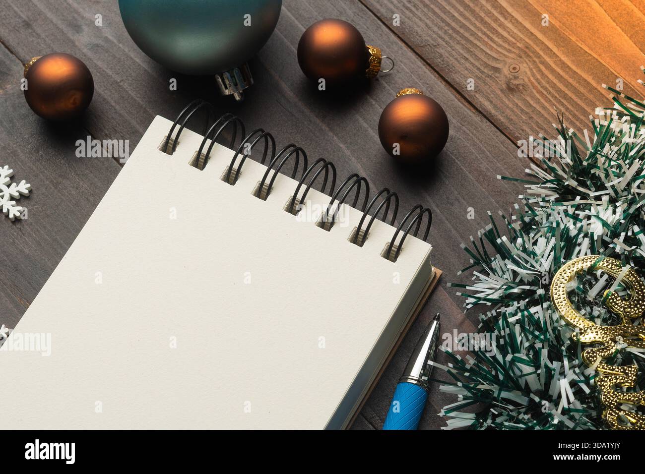 Christmas decorations and blank notebook on wooden table for holiday planning Stock Photo