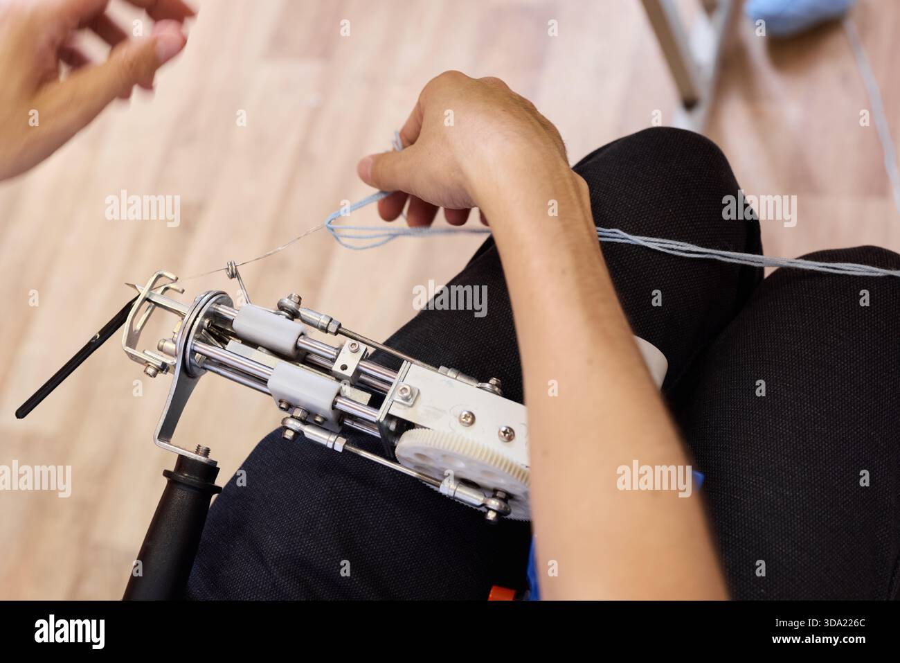 Hands using a sewing machine to stitch fabric together Stock Photo