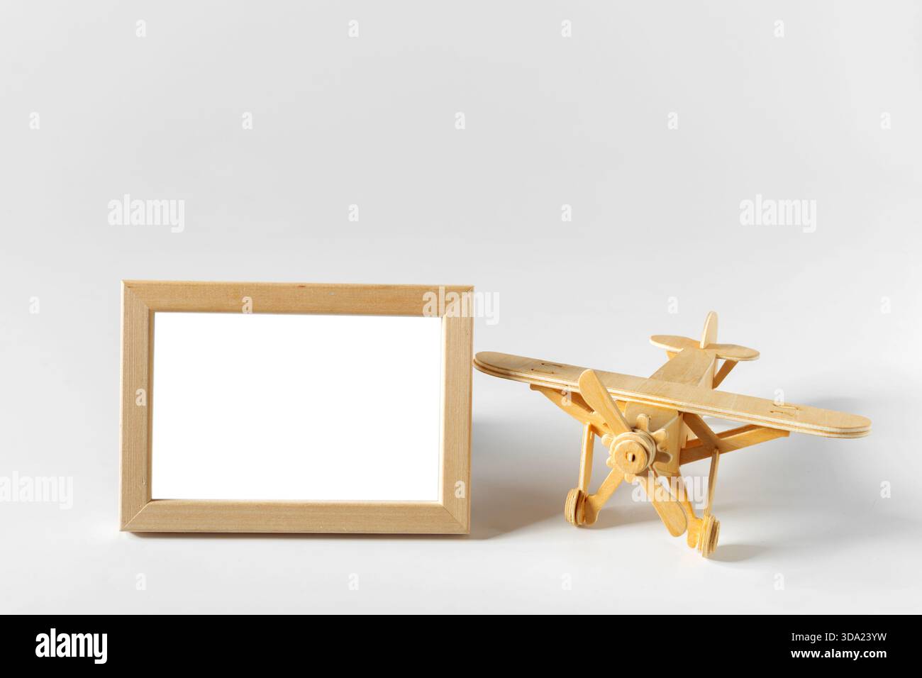 Wooden airplane model and empty frame on white background for creative ...