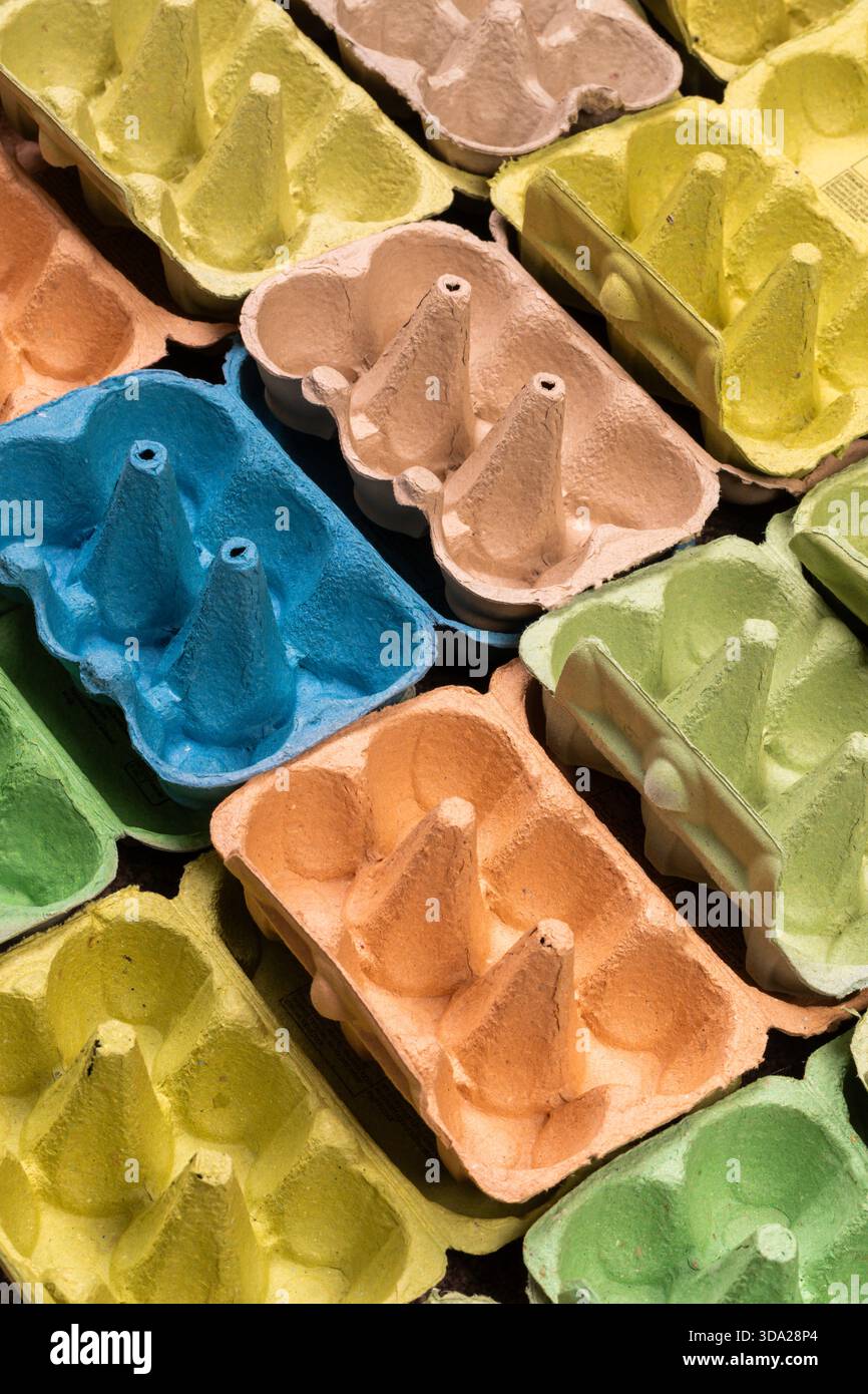 Open empty egg box cartons in different colours, viewed at an angle  in a grid pattern Stock Photo
