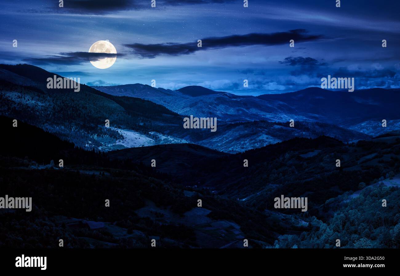 rolling forested hills in spring at night. beautiful scenery of mountainous countryside in dappled full moon light. finance investment or abstract con Stock Photo
