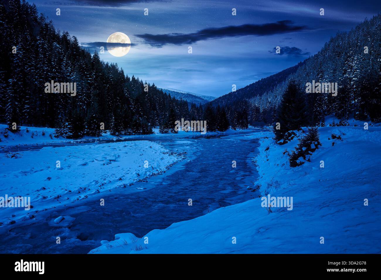 mountain river in winter at night. landscape with spruce forest and snow covered shore in full moon light. beautiful nature scenery in countryside val Stock Photo