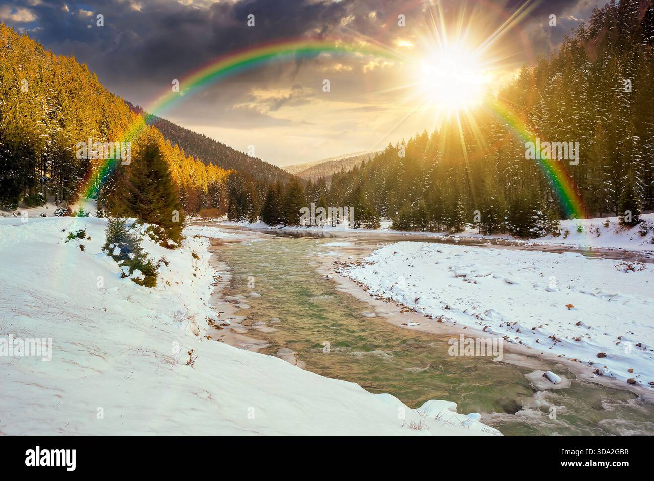mountain river in winter at sunset. landscape with spruce forest and snow covered shore in evening light. beautiful nature scenery in valley. leadersh Stock Photo