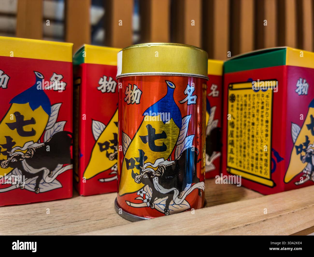 The red and gold shichimi tin sold at Yawataya Isogoro (八幡屋礒五郎) carries a chilli design and an image of Zenkoji Temple on the back, unchanged for decades. Only in Nagano is the tin sold with a design showing a running bull with a cloth tied to its horns. Stock Photo