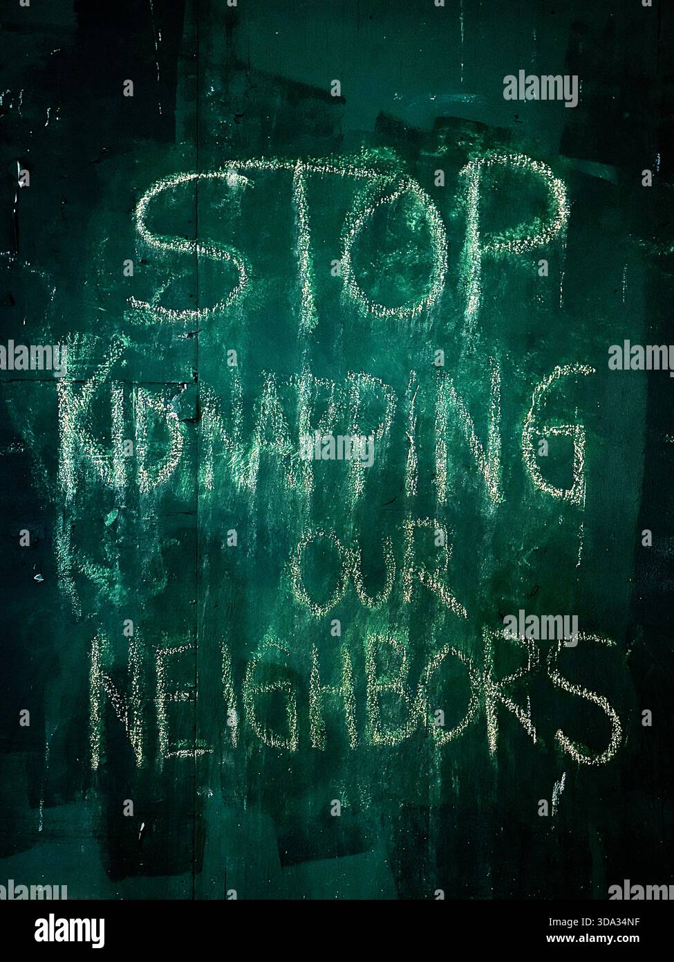 Stop Kidnapping Our Neighbors - Anti-ICE Graffiti Sign in Hell's Kitchen, NYC - Smartphone Captured Stock Image