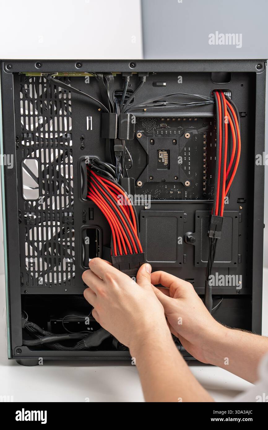 Computer Assembly Connecting Power Supply Cables inside PC Case for Optimal Performance Stock Photo