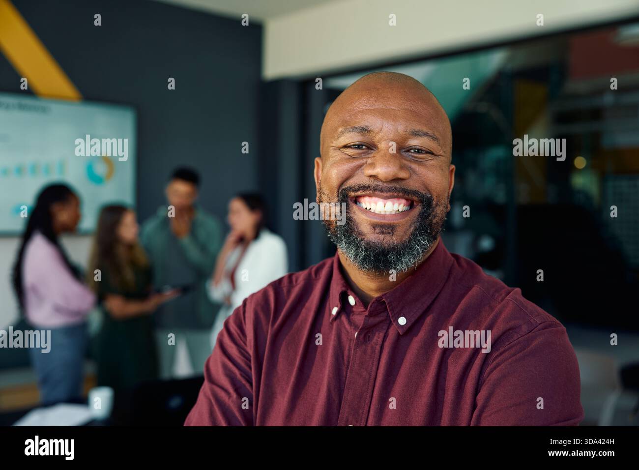 Cheerful mature black businessman standing in meeting room at workplace Stock Photo