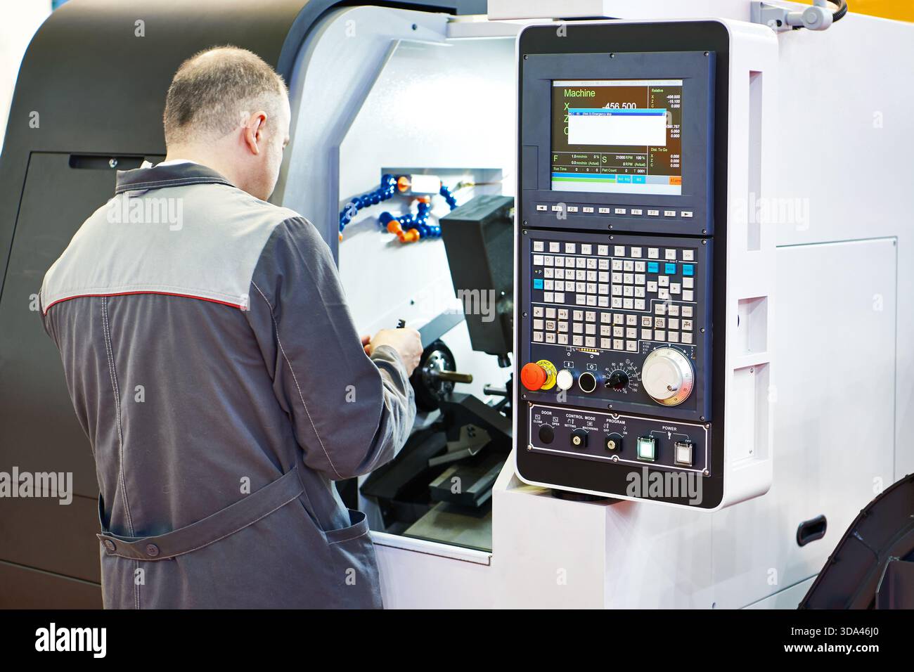 Worker at a lathe milling machine Stock Photo
