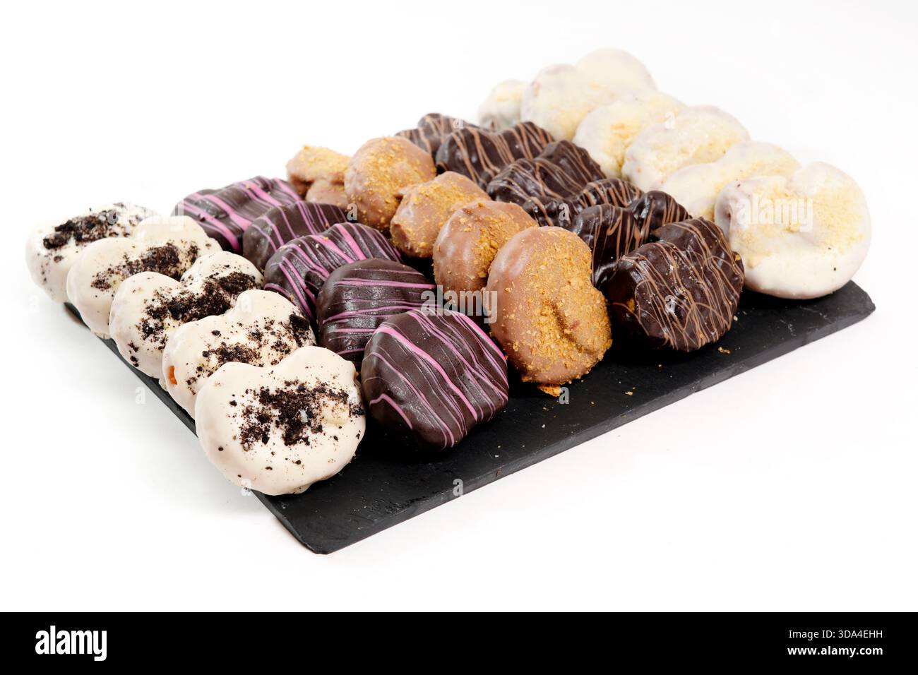 Delicious glazed mini donuts arranged on a dark serving platter Stock Photo