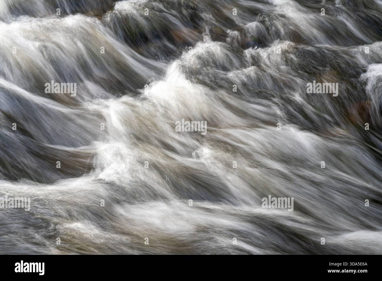 Fast flowing river water with long exposure movement Stock Photo