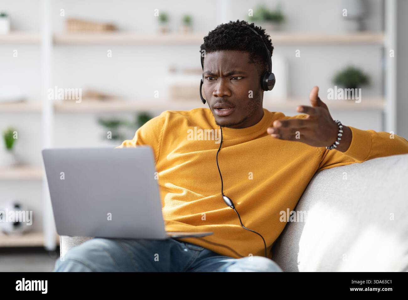 Furious black guy having video call, using laptop at home Stock Photo