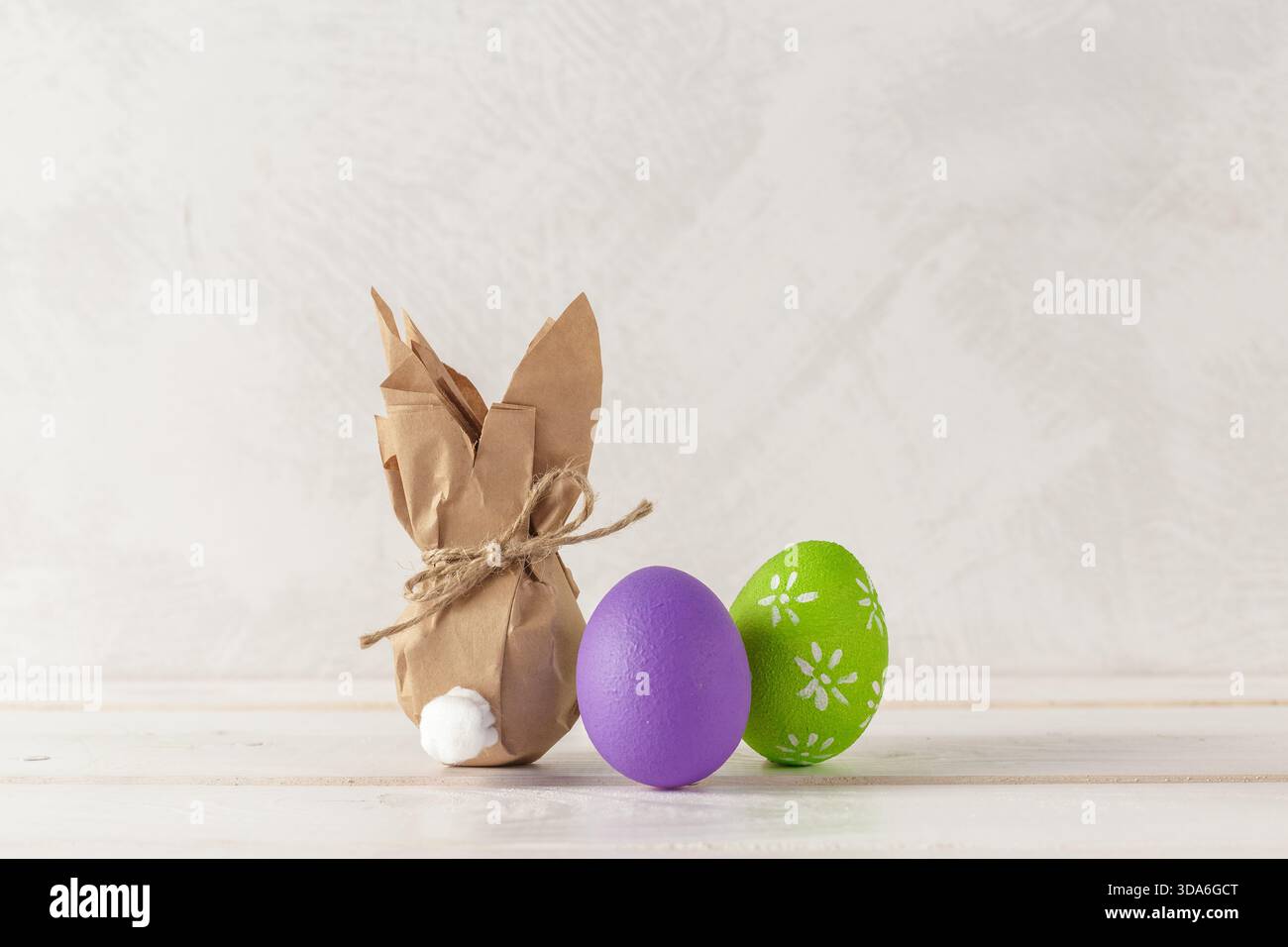 Colorful Easter decorations featuring a bunny and painted eggs on a light background Stock Photo