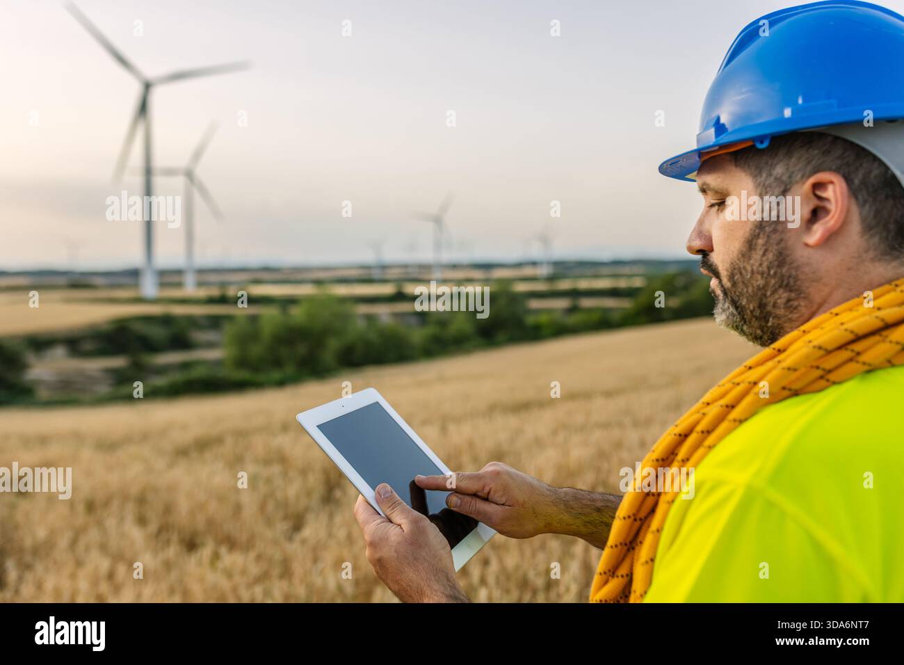 Engineer analyzing wind farm data on tablet Stock Photo