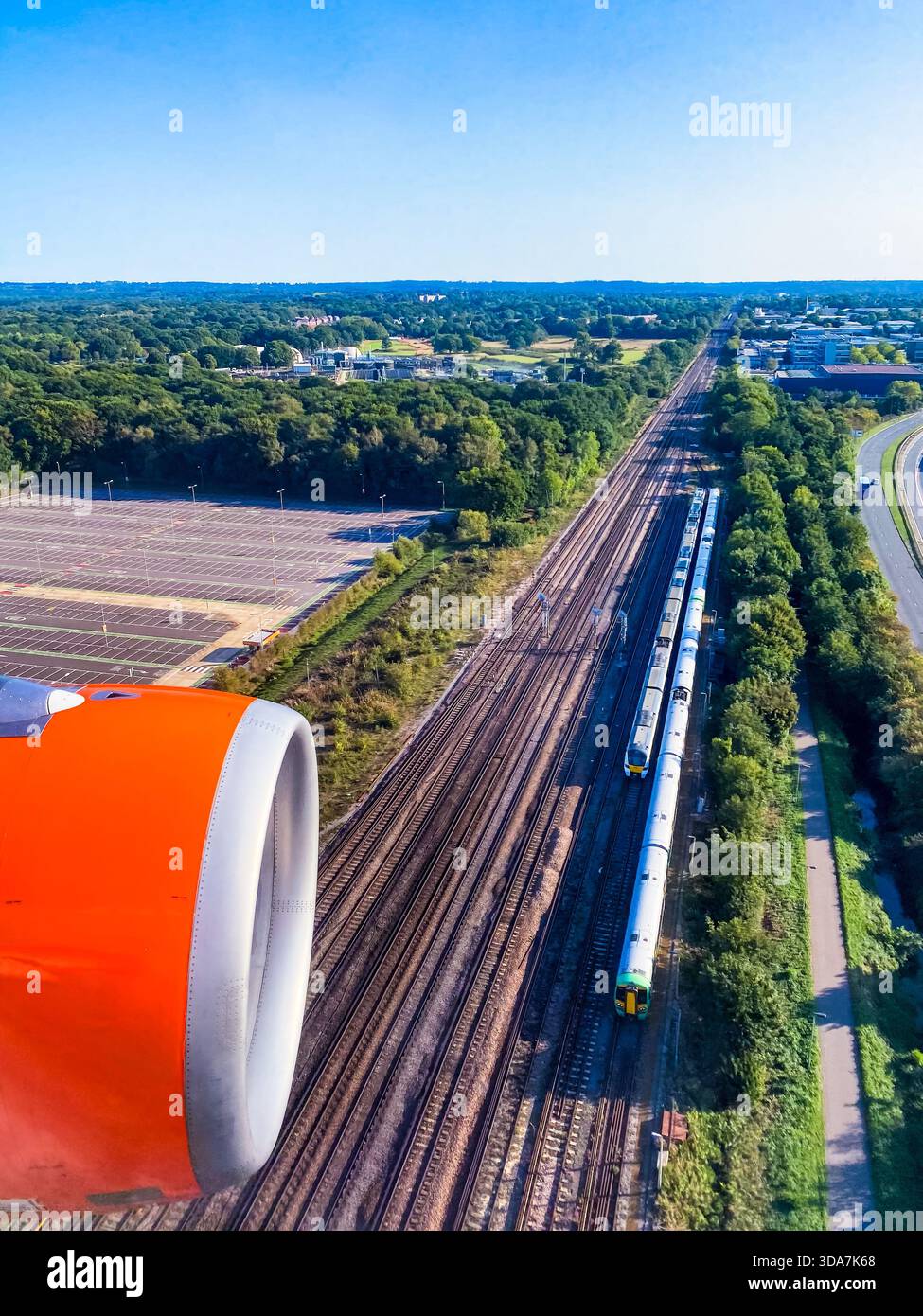 Trains on the south coast mainline, just south of Gatwick, as seen through an aircraft window in final approach to Gatwick Airport - Smartphone Captured Stock Image