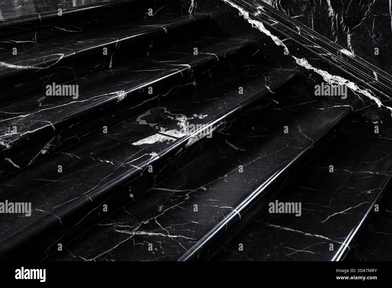 Close up polished black white marble stairs elegant texture bright veins creating dramatic contrast. Reflective surface adds depth subtle light Stock Photo
