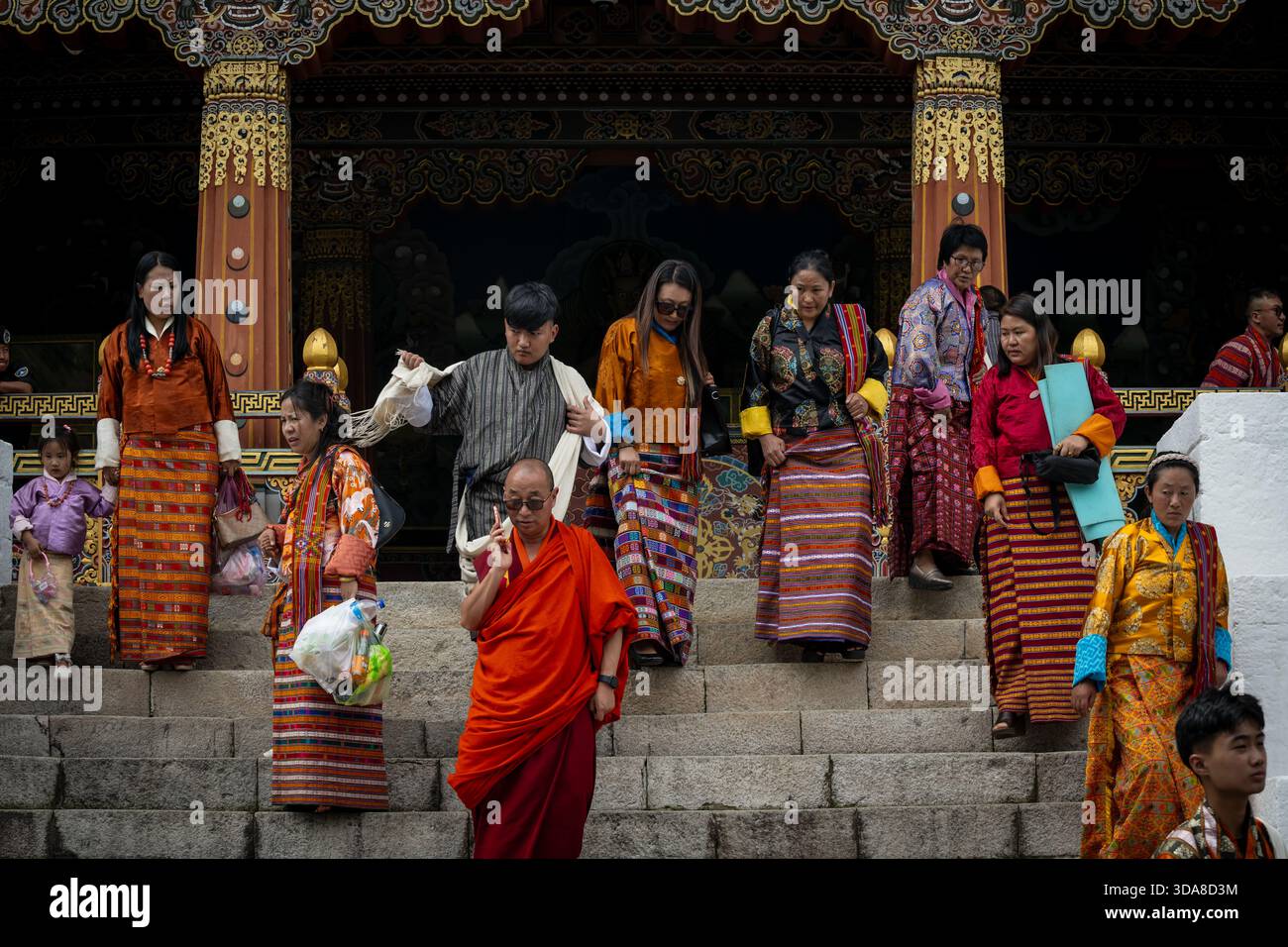 Thimphu, Bhutan - 28 September 2025: View of people descending the stone steps of a traditional Bhutanese building, adorned with intricate carvings an Stock Photo