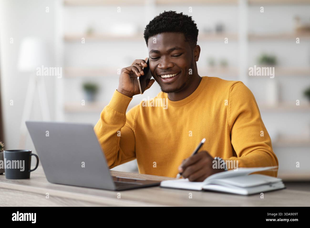 Happy black man freelancer working from home Stock Photo