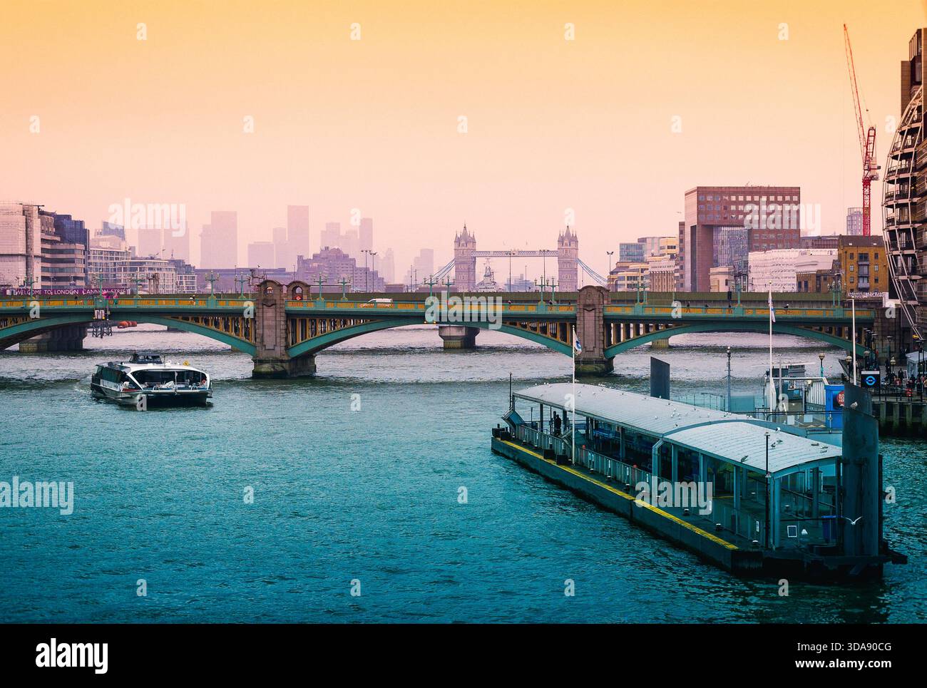 River Thames with Tower Bridge and skyscrapers of Canary Wharf in the distance. London, UK Stock Photo