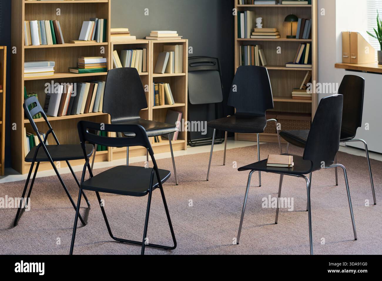 Chairs Forming Circle in Library Setting Preparing for Group Therapy Meeting Stock Photo