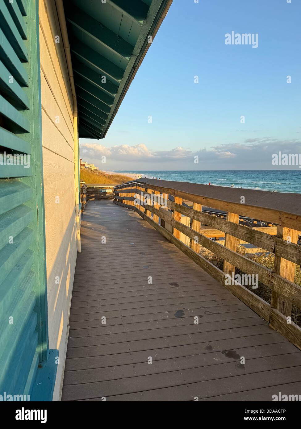 Public beach access walkway with side restroom wall and view of Gulf of Mexico water in Miramar Beach, Florida - Smartphone Captured Stock Image