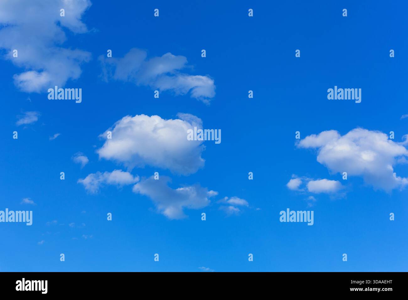 White clouds scattered across a bright blue sky Stock Photo