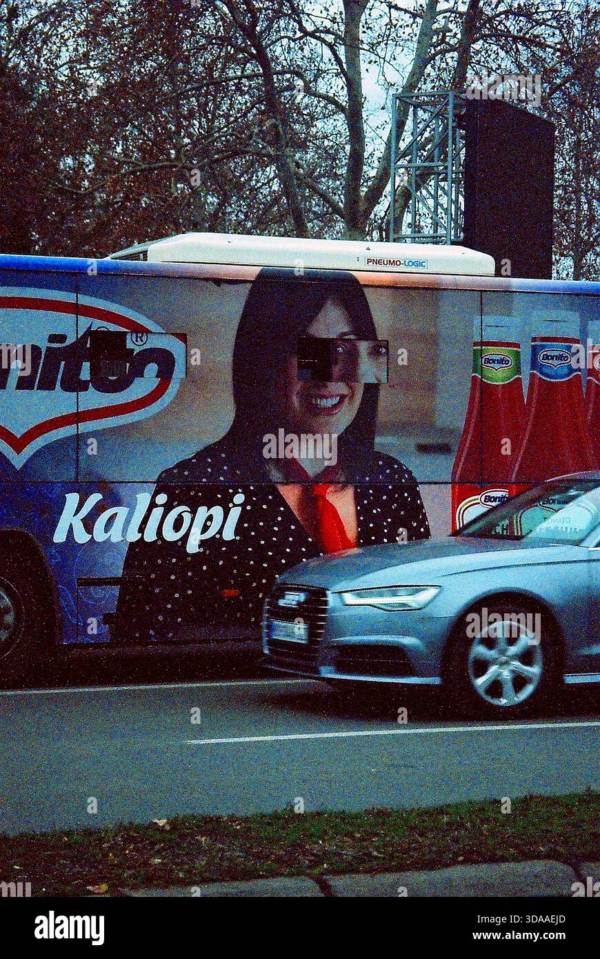 Analog grainy shot of a city bus ad with a large portrait of a laughing ...