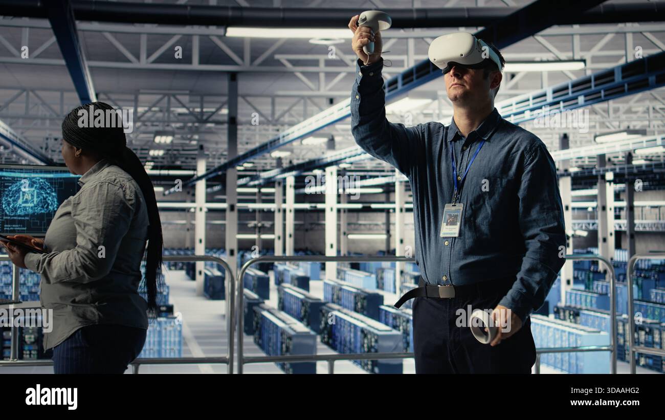 Server farm programmer uses VR headset to install updates and keep AI systems running. Data center employee uses virtual reality tech to write code improving infrastructure output, camera A Stock Photo