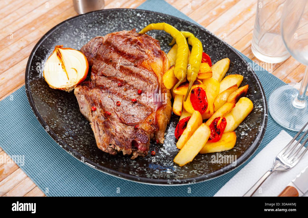 Beef sirloin steak with fries, pepper, onion, tomatoes Stock Photo - Alamy