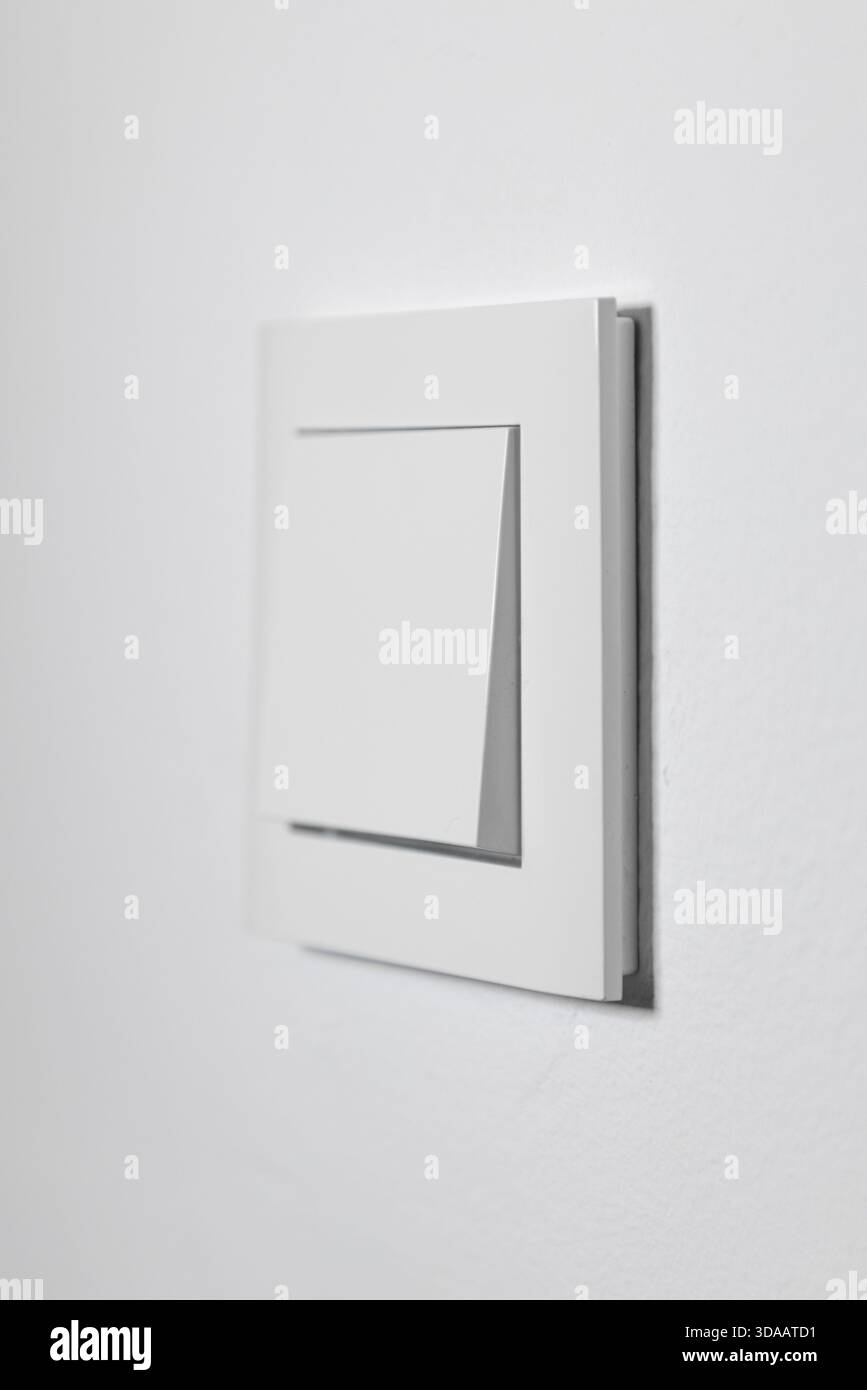 White light switch on a white wall, minimalistic design Stock Photo