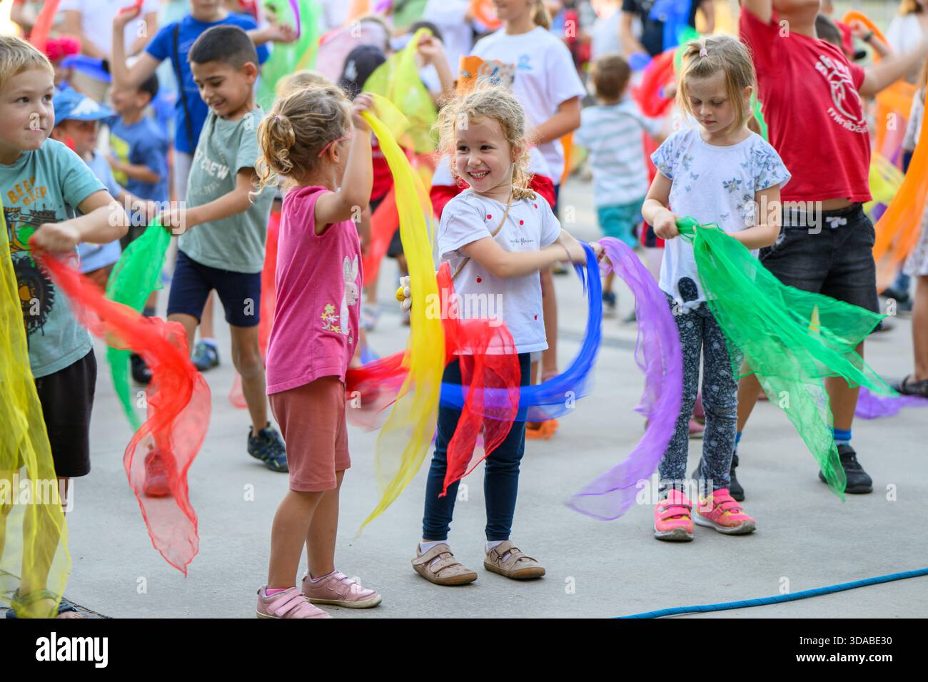 Children dance with colourful scarves during an outdoor group activity, part of the Bratislava March for Life event. - Stock Image