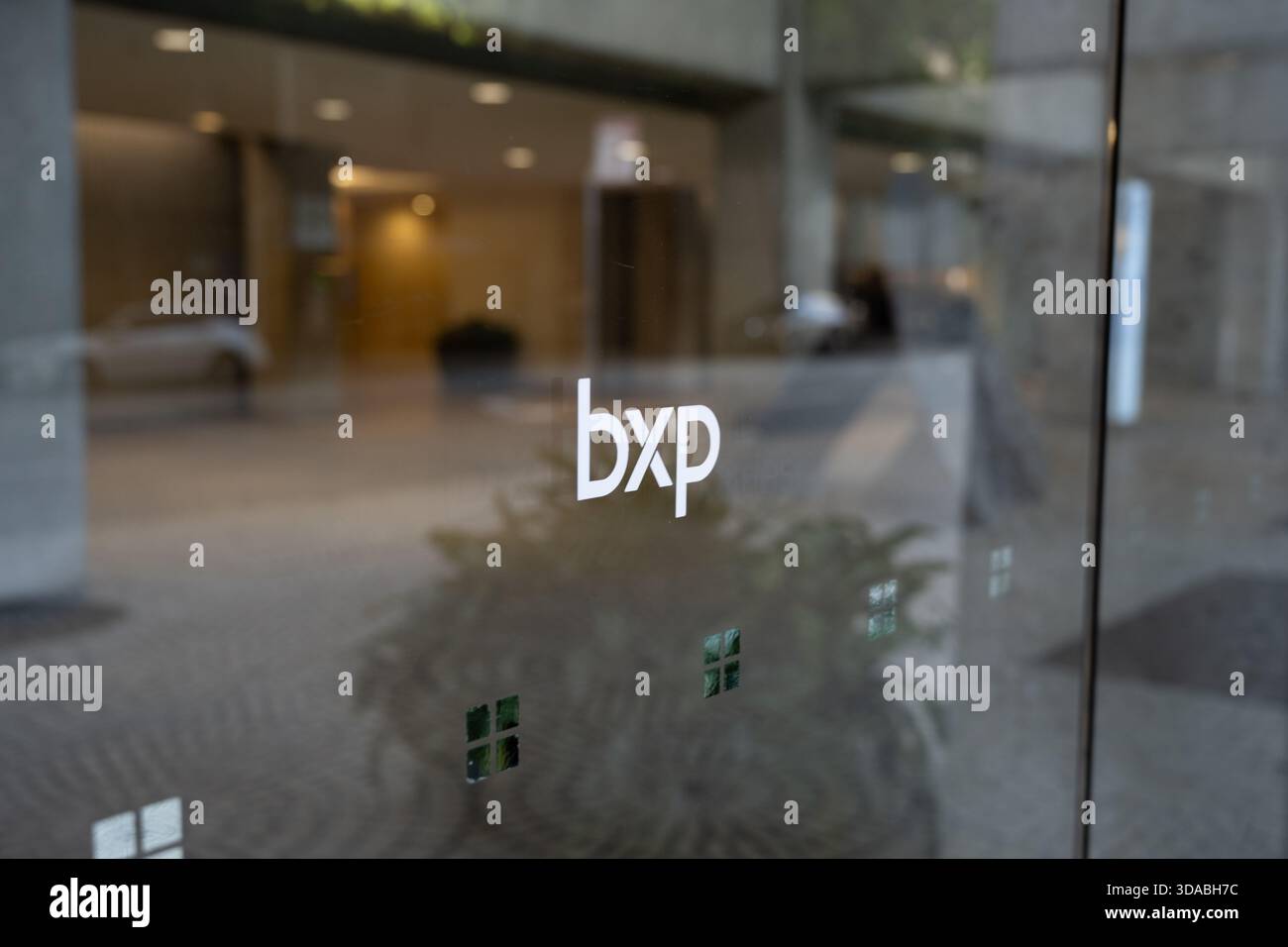 Close-up of bxp logo on glass entrance with blurred lobby reflection ...