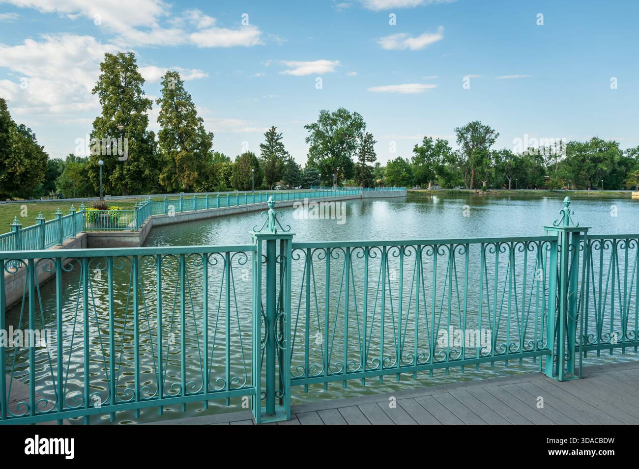 The Ornate Ironwork fence in a Vintage Aqua color surrounding part of Ferril Lake at City Park in Denver, Colorado. Stock Photo
